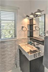 a bathroom with a sink and a mirror at Park Shore Suites St Pete Beach in St Pete Beach