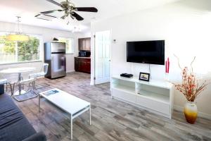 uma sala de estar com um sofá, uma televisão e uma mesa em Park Shore Suites St Pete Beach em St. Pete Beach