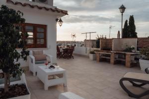 patio z krzesłami i stołem na dachu w obiekcie Menurka-Santa Clara w mieście Ciutadella