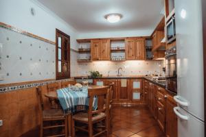 a kitchen with wooden cabinets and a table with chairs at Menurka-Santa Clara in Ciutadella