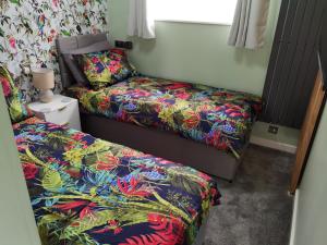a bedroom with two beds and a bedskirts at Headwards Retreat in Hemsby