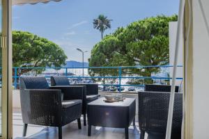 a balcony with chairs and tables and a view of the ocean at Right by the beaches 90m2 on the Croisette in Cannes