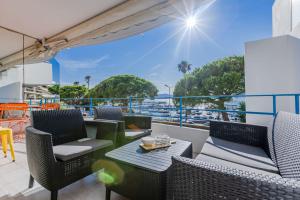 a balcony with chairs and tables and a view of the ocean at Right by the beaches 90m2 on the Croisette in Cannes