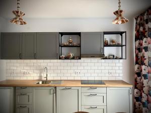 a kitchen with white cabinets and a sink at Rynek_28 in Ciężkowice