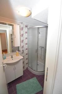 a bathroom with a shower and a sink and a mirror at Apartmani Mihaela in Šibenik