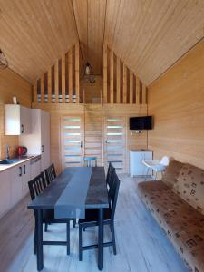 a dining room with a table and a couch at Rodzinna Przystań in Jarosławiec