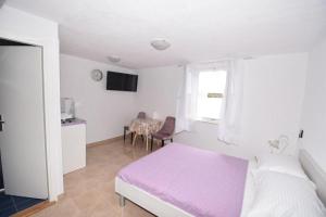 a bedroom with a bed and a table and a window at Apartmani Mihaela in Šibenik