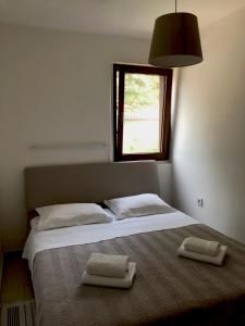 a bedroom with a bed with two towels on it at Apartments Tomic in Premantura