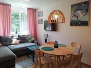 a living room with a table and a couch at Meva Apartment Gdańsk in Gdańsk