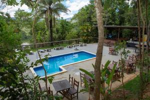 a swimming pool with chairs and a table at Planeta Macacos in Macacos