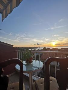 een tafel op een balkon met een zonsondergang op de achtergrond bij Sea view apartment Poreč in Poreč