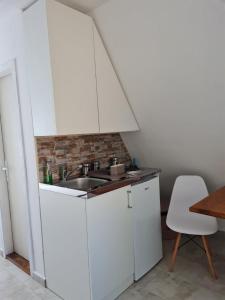 a kitchen with white cabinets and a sink at Apartmani Radaković in Vrdnik