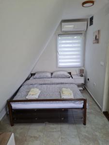 1 cama en un dormitorio con ventana en Apartmani Radaković en Vrdnik