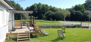 a wooden deck with chairs and an umbrella at Ma maison de vacances en Bretagne in Meillac