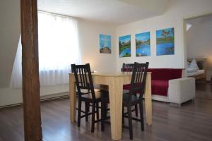 a dining room table with four chairs and a couch at Ferienwohnung Gruppenhaus bis 12 Personen in Neuhausen