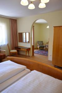 a hotel room with a bed and a living room at Hotel Garni Sonnenhof in Rottach-Egern