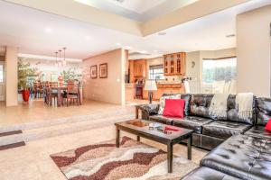 a living room with a leather couch and a table at Alluring Palm Desert Retreat in Palm Desert