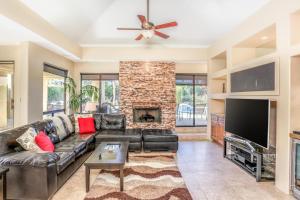 a living room with a leather couch and a fireplace at Alluring Palm Desert Retreat in Palm Desert
