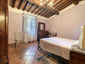 a bedroom with a bed and a chair at Agriturismo Dominus Domenico in Cortona