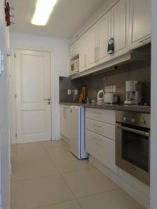 een keuken met witte kasten en een witte deur bij Green Park Apartamento de 1amb en PB con Jardín in Punta del Este