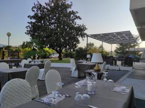 a restaurant with tables and chairs and a tree at Forum Palace Hotel in Cassino