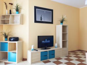 Televízia a/alebo spoločenská miestnosť v ubytovaní Apartament z balkonem ul. Spacerowa 2
