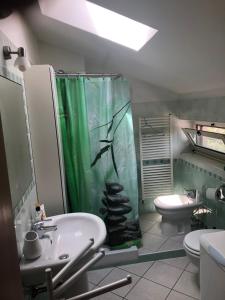 baño con cortina de ducha verde y lavamanos en Monolocale Wendy en Quarto Inferiore