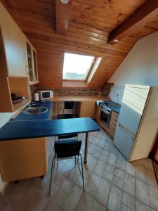 a kitchen with a blue counter top and a refrigerator at Vörös Macska Vendégház in Szentkirályszabadja