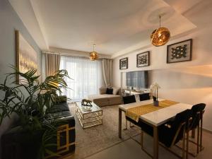 a living room with a table and a dining room at Fabulous 1 Bedroom Private Apartment - Waterfront Property in Ras al Khaimah
