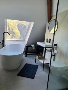 een badkamer met een bad, een toilet en een wastafel bij Villa Le Ponteil in Les Deux Alpes