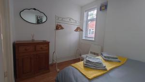 een slaapkamer met een bed, een dressoir en een spiegel bij Molesey near Hampton Court, Viking Short Stays in West Molesey