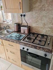 a kitchen with a stove and a sink at Molesey near Hampton Court, Viking Short Stays in West Molesey