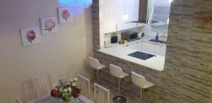 a kitchen with white counters and white chairs at Villa 2527 San Lameer in Southbroom