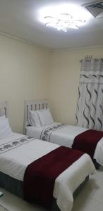 a bedroom with two beds and a chandelier at Villa 2527 San Lameer in Southbroom +34 photos