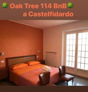 1 dormitorio con un roble y un cartel de castiglitzario en OAK TREE 114 BnB, en Castelfidardo