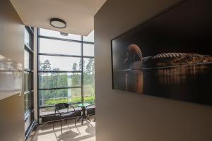 a living room with a television on a wall at Haltia Lake Lodge nature boutique hotel & glamping in Espoo