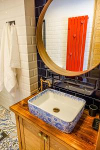 uma casa de banho com um lavatório azul e branco e um espelho. em Zielony Domek w Nartach - Mazury em Narty