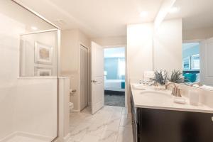 uma casa de banho branca com um chuveiro e um lavatório. em 820DSD - The Retreat at ChampionsGate em Davenport
