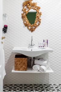 a bathroom with a sink and a mirror and towels at Aniana Alojamiento Boutique in Logroño