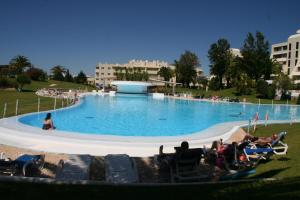 
a swimming pool with people in it at Vila Marachique Mariosilvat in Alvor
