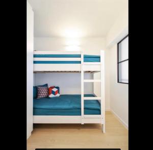 een slaapkamer met 2 stapelbedden met blauwe lakens bij Luxe appartement Arte, 50m van het Zoute strand in Knokke-Heist