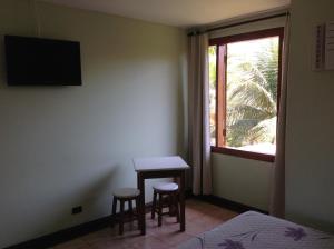 een slaapkamer met een tafel en twee krukken en een raam bij Pousada das Pedras Paraty -RJ in Paraty
