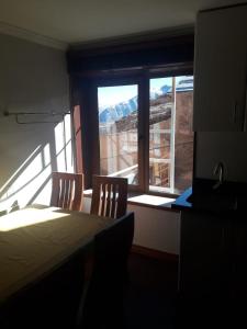 Zimmer mit einem Tisch, 2 Stühlen und einem Fenster in der Unterkunft El Colorado Habitamar in El Colorado