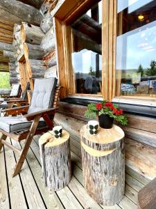 ein Stuhl auf einer Veranda mit Baumstämmen und einem Fenster in der Unterkunft Ruka View, 4BDR spacious chalet, perfect for families, walk to slopes, Family Park, National Park, Bike Park - Lapland Villas in Ruka