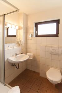 
a bathroom with a toilet, sink and mirror at ITM Hotel Deutsches Haus in Hamburg
