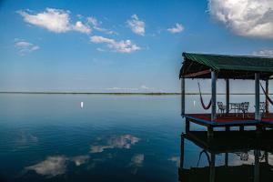 a dock on a body of water with two chairs at Seven Blue House Village & Lodge in Bacalar