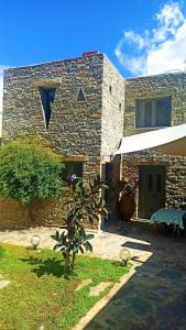 a stone house with a tree in front of it at Casa di Pietra in Neápolis