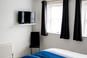 um quarto com uma cama e uma televisão na parede em Milltown Lough Eske Bed & Breakfast em Ardeevin