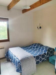 a bedroom with a bed with a blue and white blanket at Chez Fanny - Les Tuileries - Gîte 1-4 pers. avec jardin privatif - proche Cahors in Le Montat