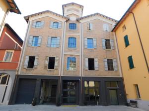 un viejo edificio de ladrillo con un reloj en la parte superior en Piumaviola Beds & Apartments en Parma
